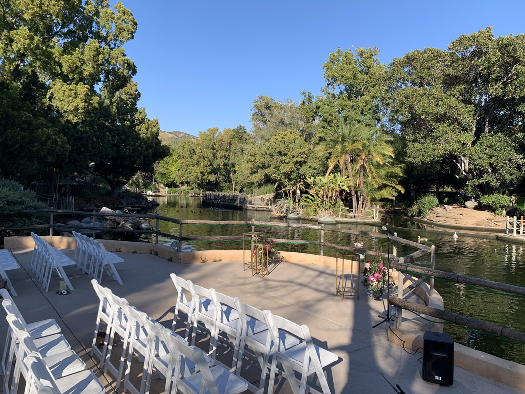 The Prado venue with white chairs by a serene lakeside, ideal for weddings and retreats.