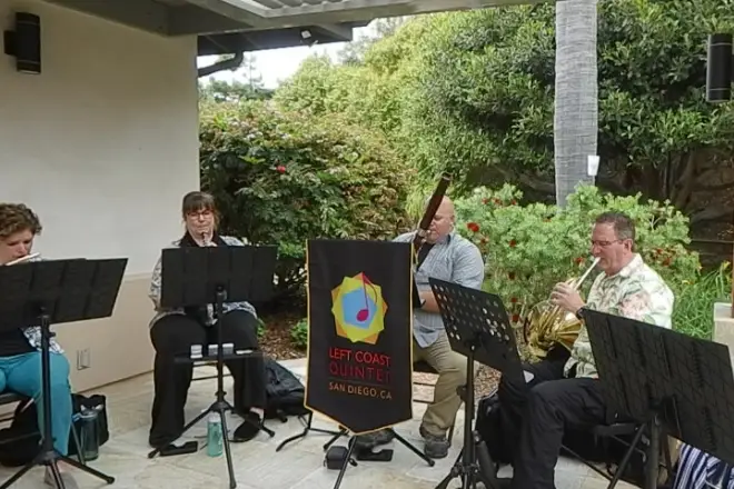 Mingei Museum outdoor concert with musicians in greenery, perfect for social gatherings.