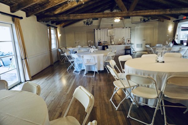 Auditorium in Sweetwater Woman's Club with round tables, ideal for events and gatherings.