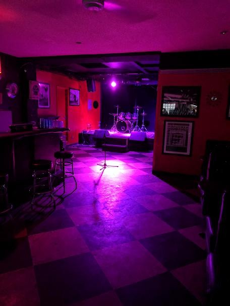 Vibrant Til-Two Club stage with drum kit, perfect for live music events and gatherings.