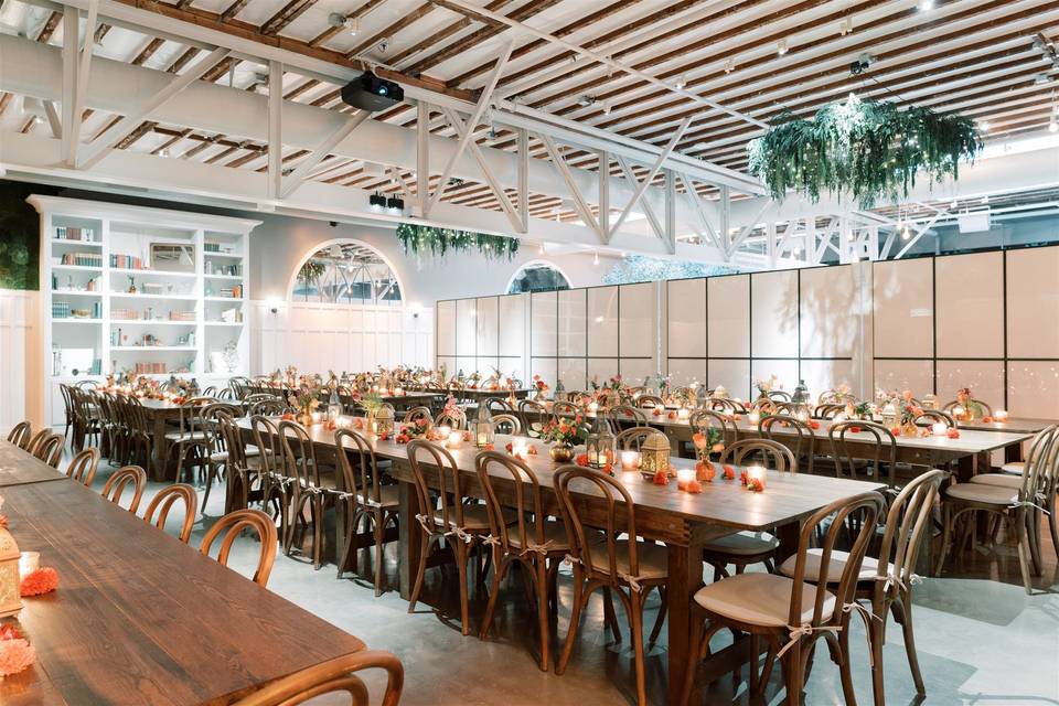 Elegant event space with wooden tables and floral centerpieces for gatherings.