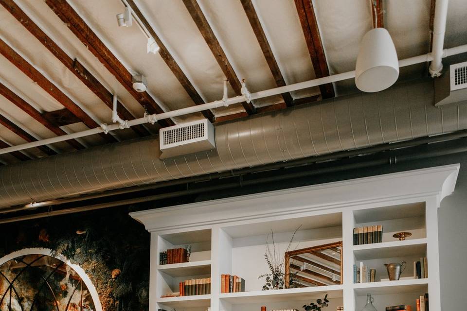 Stylish Flora Bookcase Room with wooden beams, perfect for intimate meetings and events.