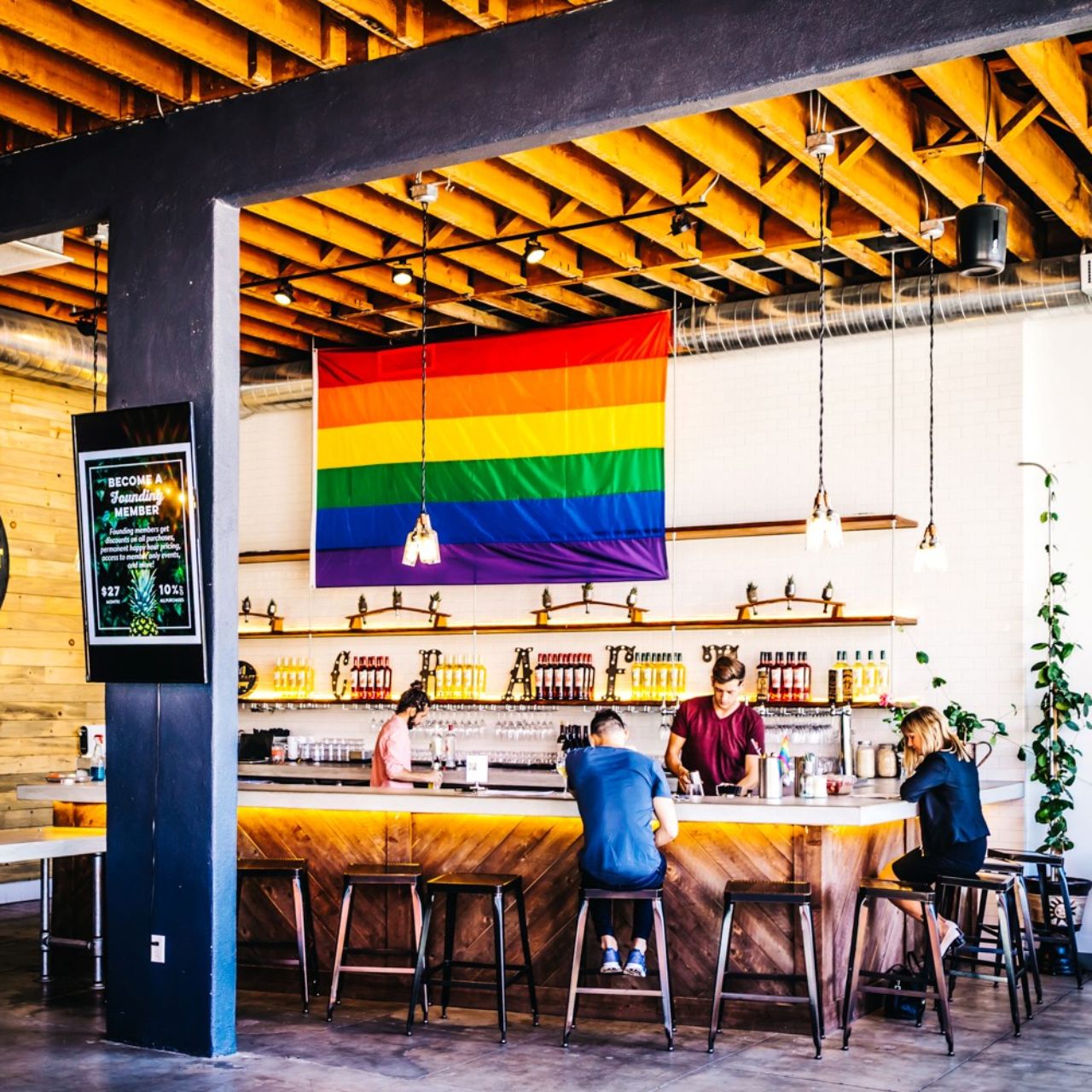 Cozy Corner bar with rainbow flag, perfect for casual networking events and social gatherings.