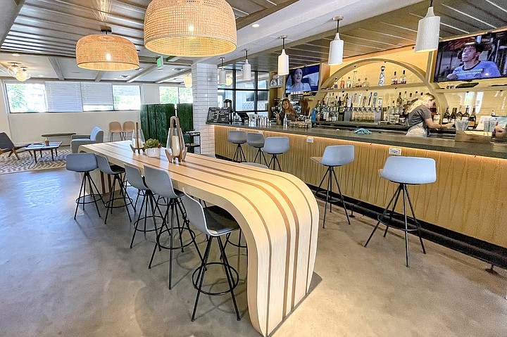 Modern lounge bar with curved wooden table, ideal for networking events and casual meetings.