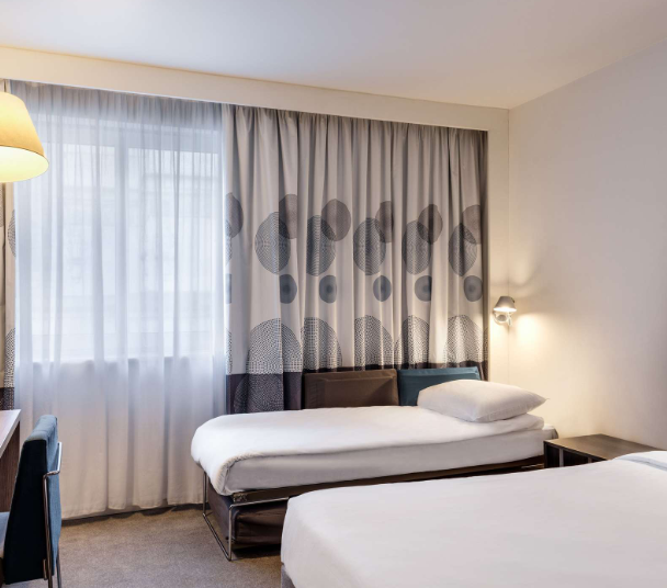 Modern hotel room with two single beds at Novotel London Tower Bridge, perfect for events.