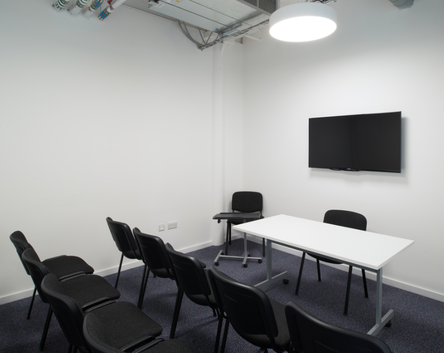 Minimalist conference room with central table, ideal for meetings and presentations.