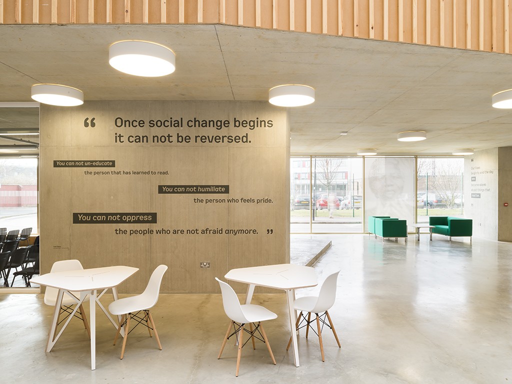 Modern meeting room with concrete walls, ideal for workshops and brainstorming sessions.