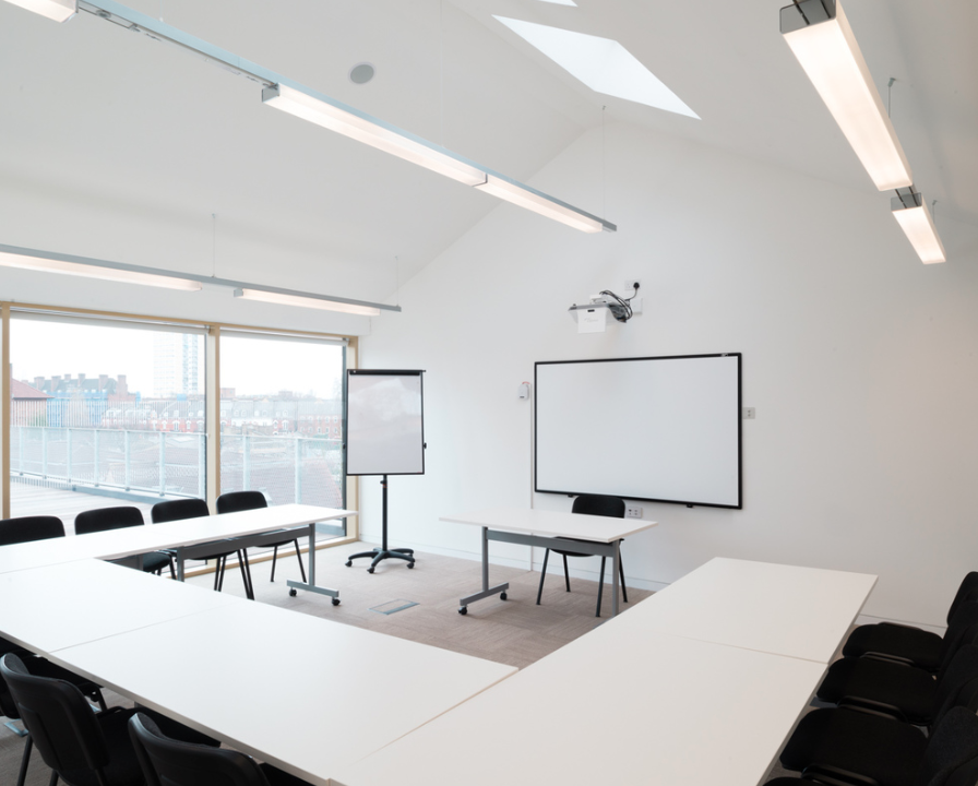 Modern meeting room with flexible seating and natural light for workshops and presentations.