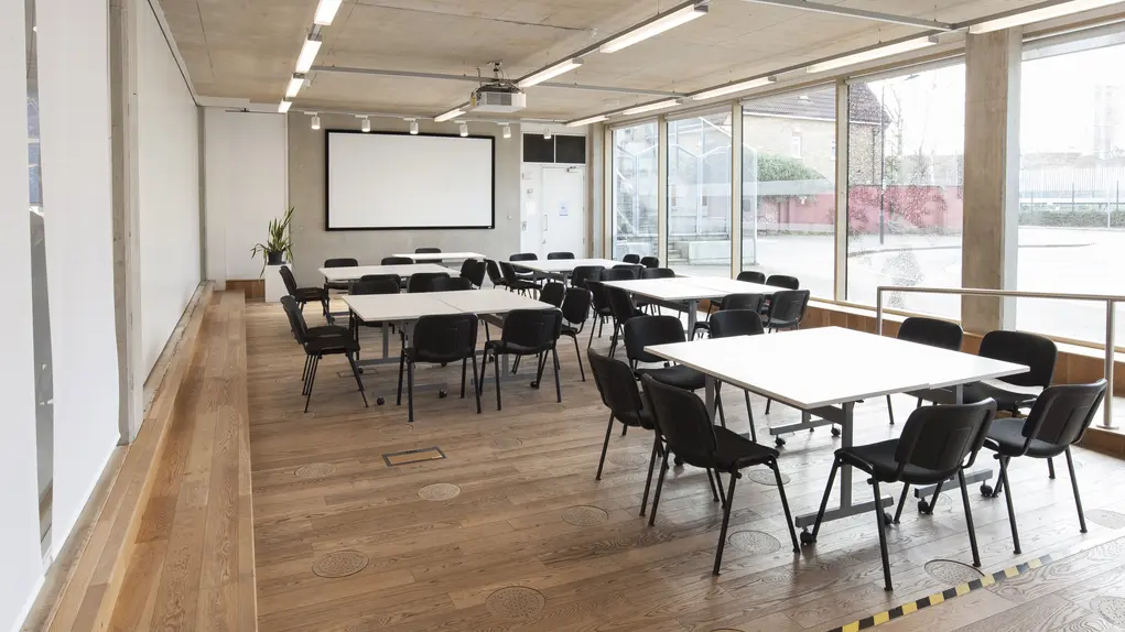 Versatile meeting room with modular furniture, ideal for workshops and presentations.