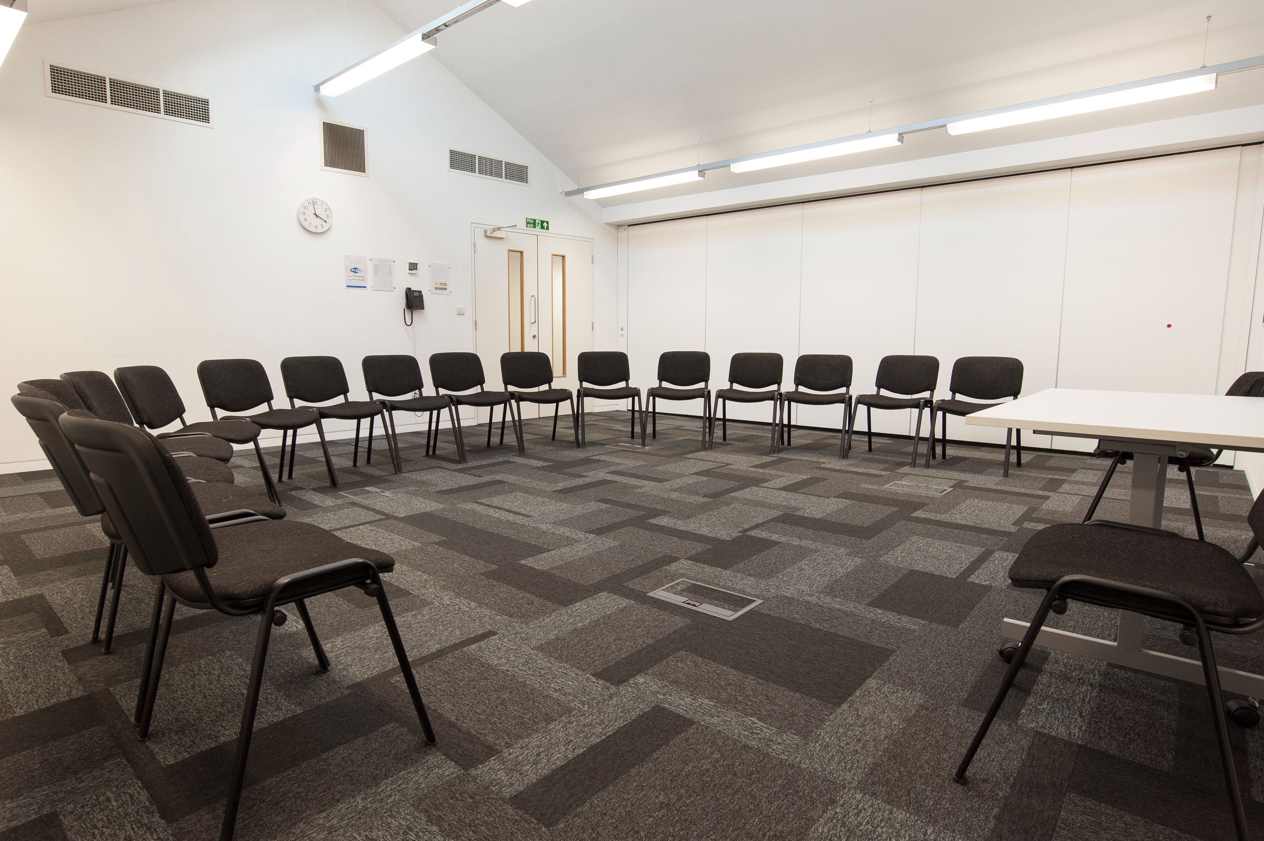 Versatile meeting room with circular seating for collaborative workshops at The Foundry.