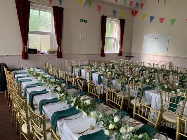 Elegant banquet hall with white linens, gold chairs, perfect for celebrations and gatherings.