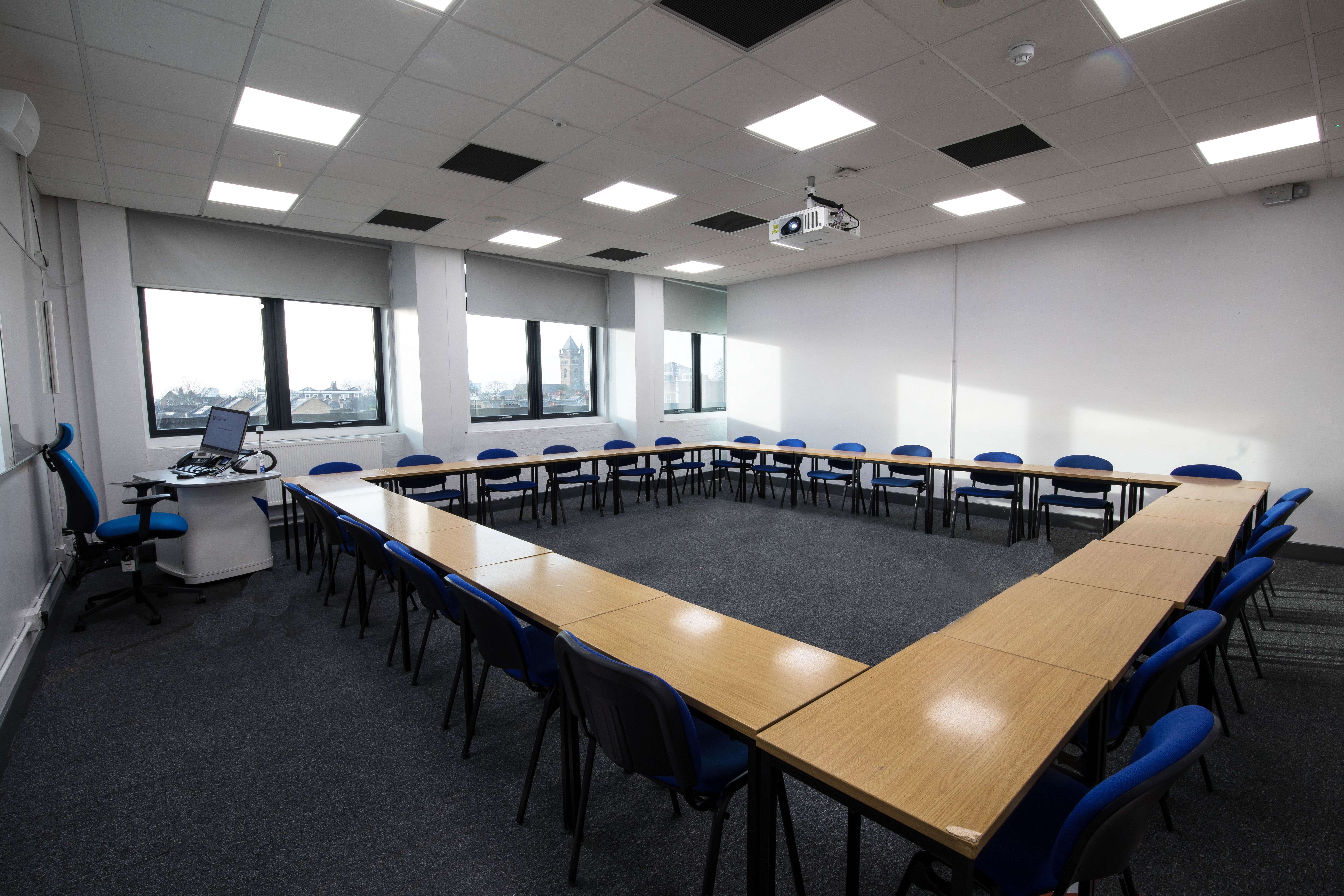 Well-lit U-shaped classroom at University of West London, ideal for workshops and meetings.