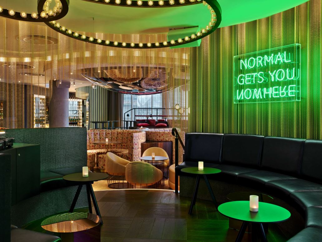 Vibrant W London event space with neon sign, ideal for creative meetings and social gatherings.