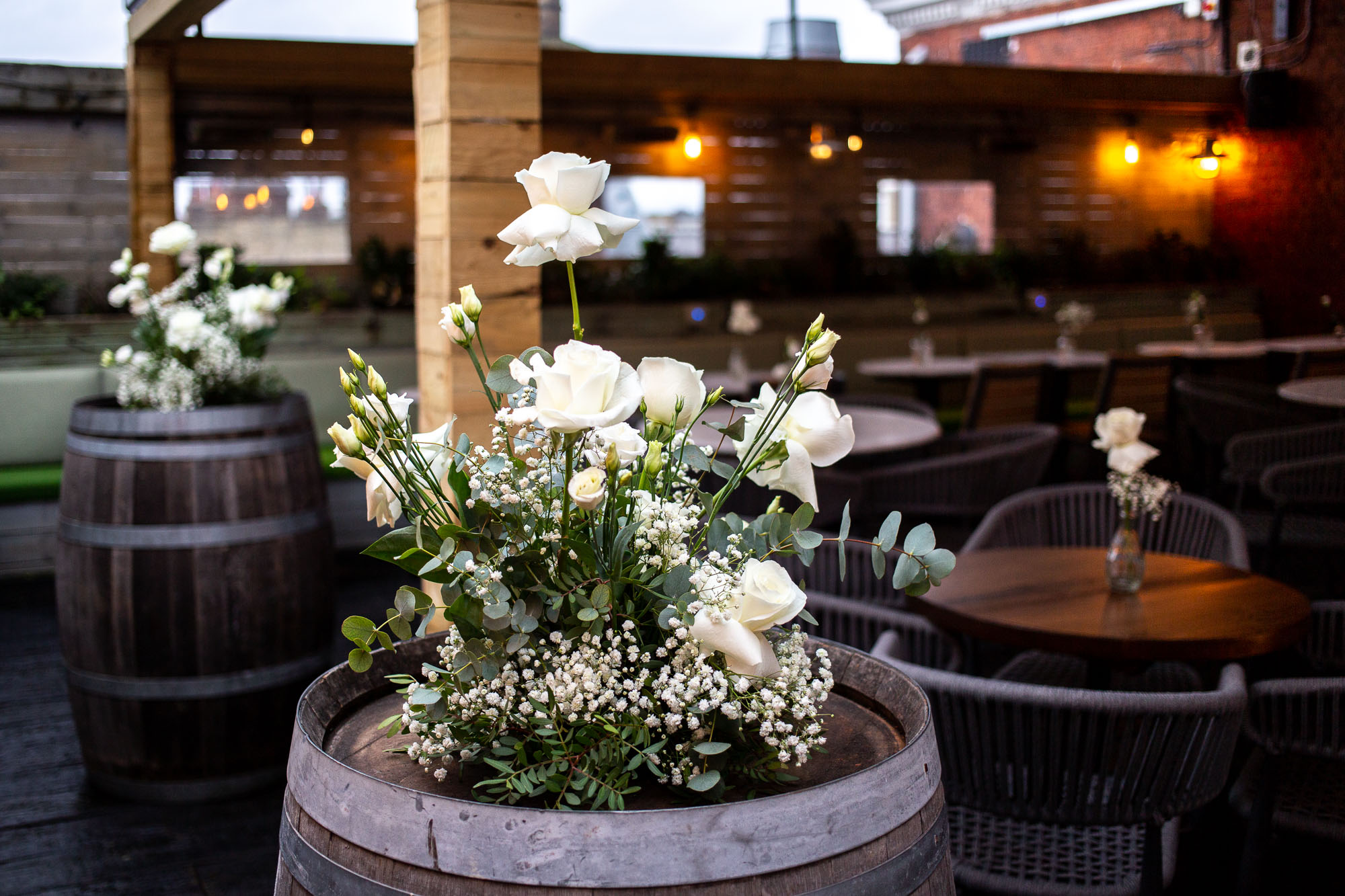 Elegant outdoor event space with floral centerpieces, ideal for weddings and receptions.