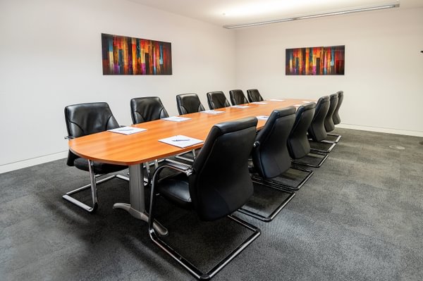 Modern conference room with wooden table and ergonomic chairs for professional meetings.
