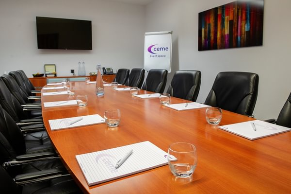 Medium Boardroom at CEME Events Space, featuring a long wooden table for professional meetings.
