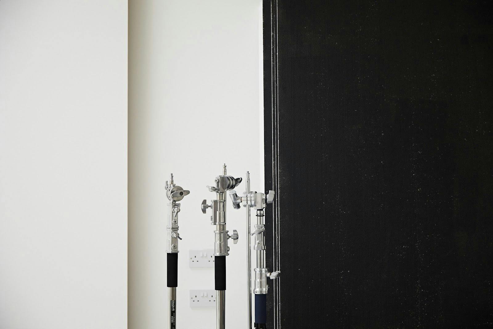 Minimalist portrait studio setup with lighting stands for versatile event production.