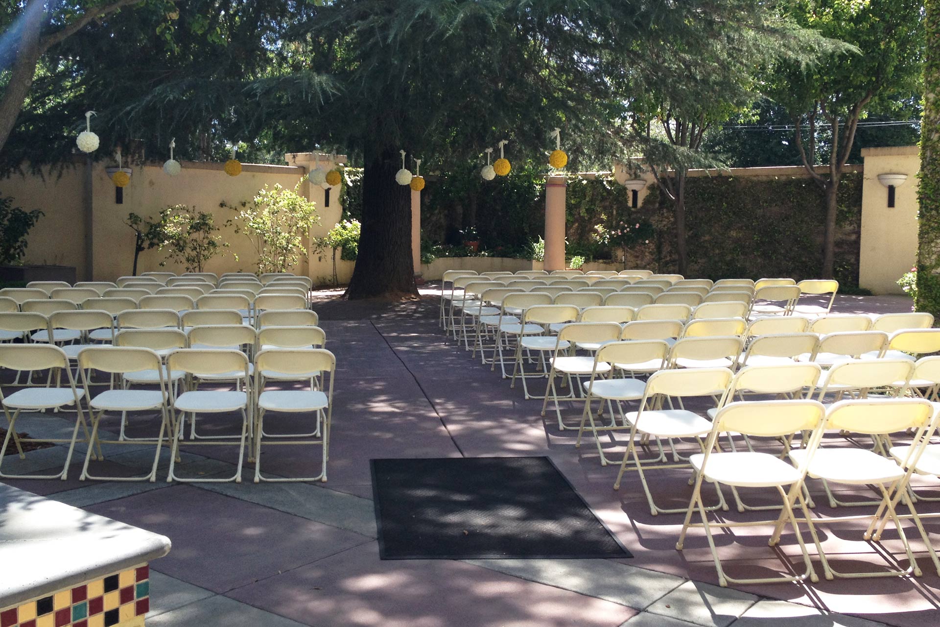 Enclosed patio event space with white chairs, ideal for ceremonies at Historic Hotel Woodland.