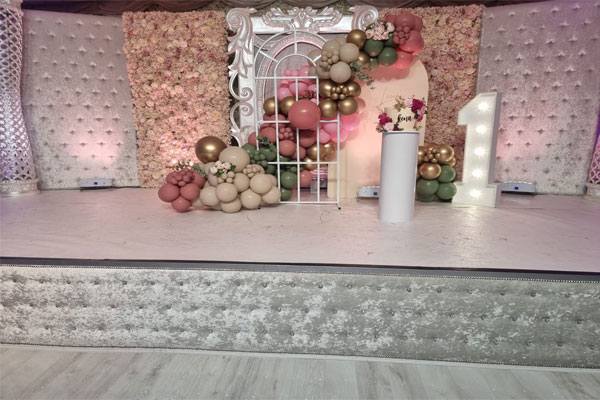 Elegant birthday party hall with floral backdrop and plush seating in Digbeth.