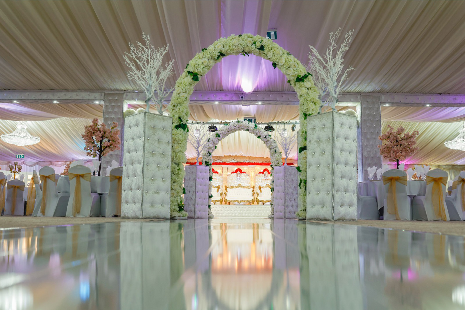 Elegant birthday party hall in Digbeth with floral arches and soft lighting.