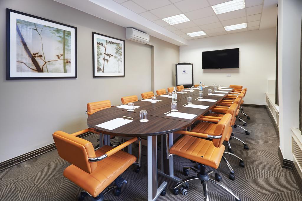Boardroom at DoubleTree by Hilton London with oval table and ergonomic chairs for meetings.