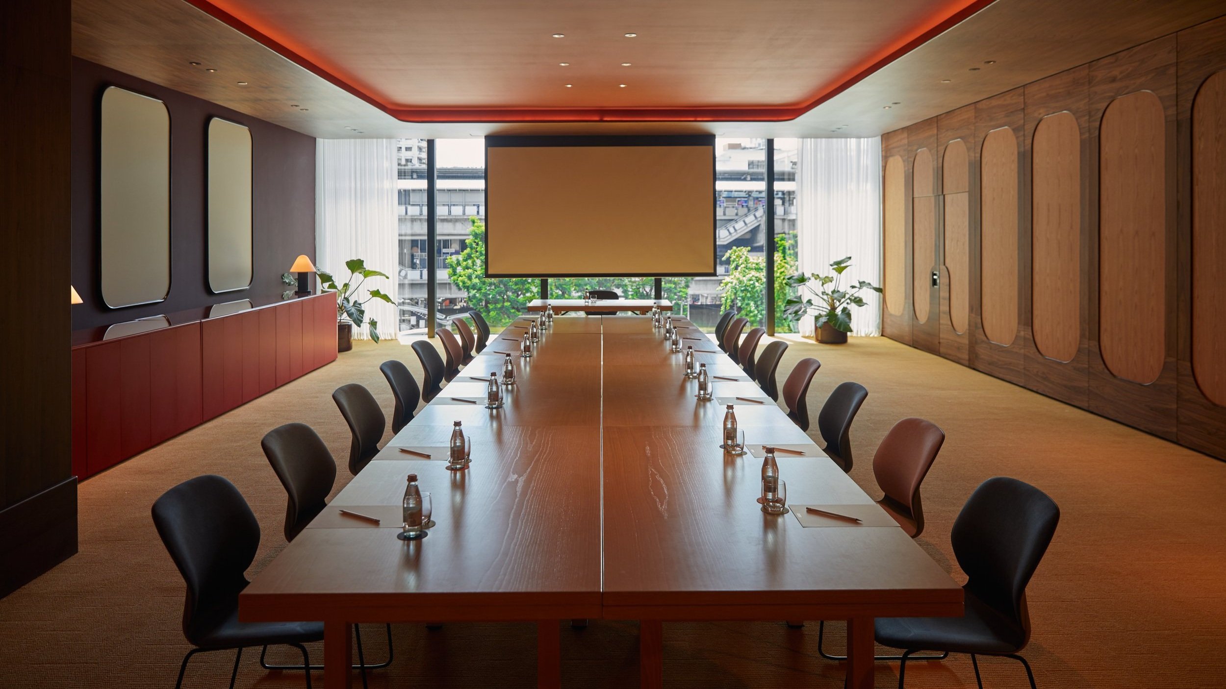 Modern conference room with wooden table, ideal for private meetings and events.