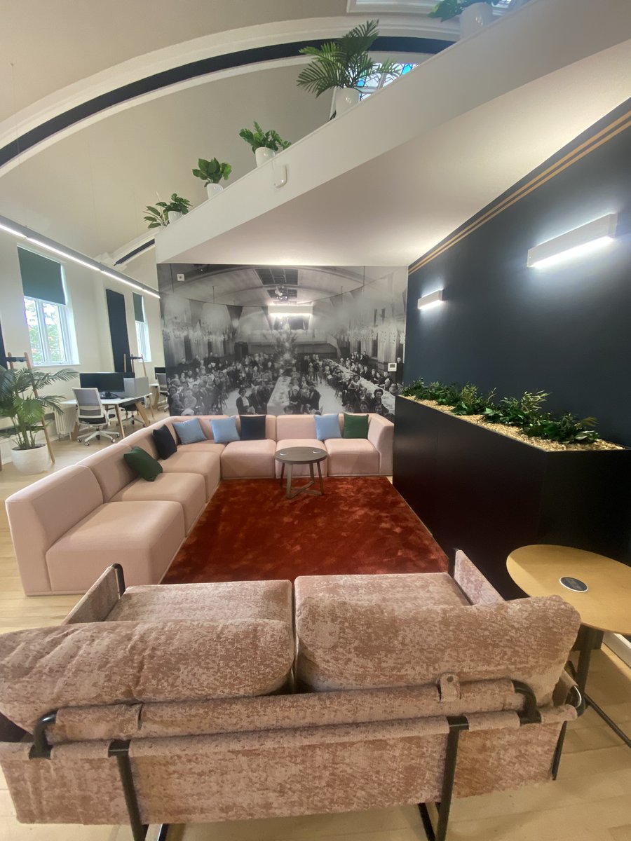 Private office pods with pink seating and mural, perfect for meetings and events.