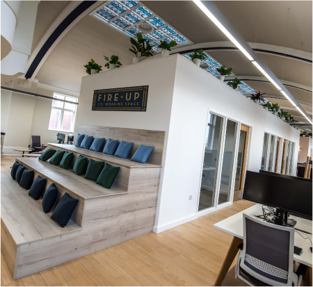 Modern private office pods with tiered seating for workshops and team-building events.
