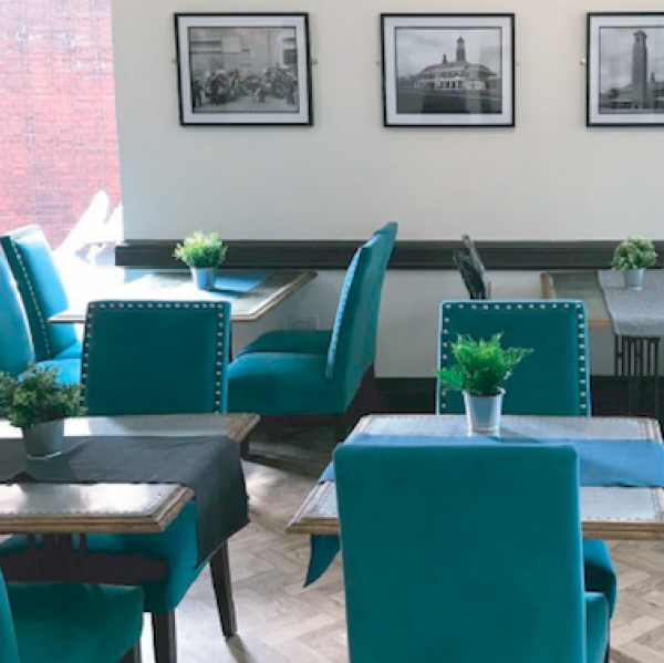 Stylish meeting space with teal chairs for networking events in Fire Up Rochdale.
