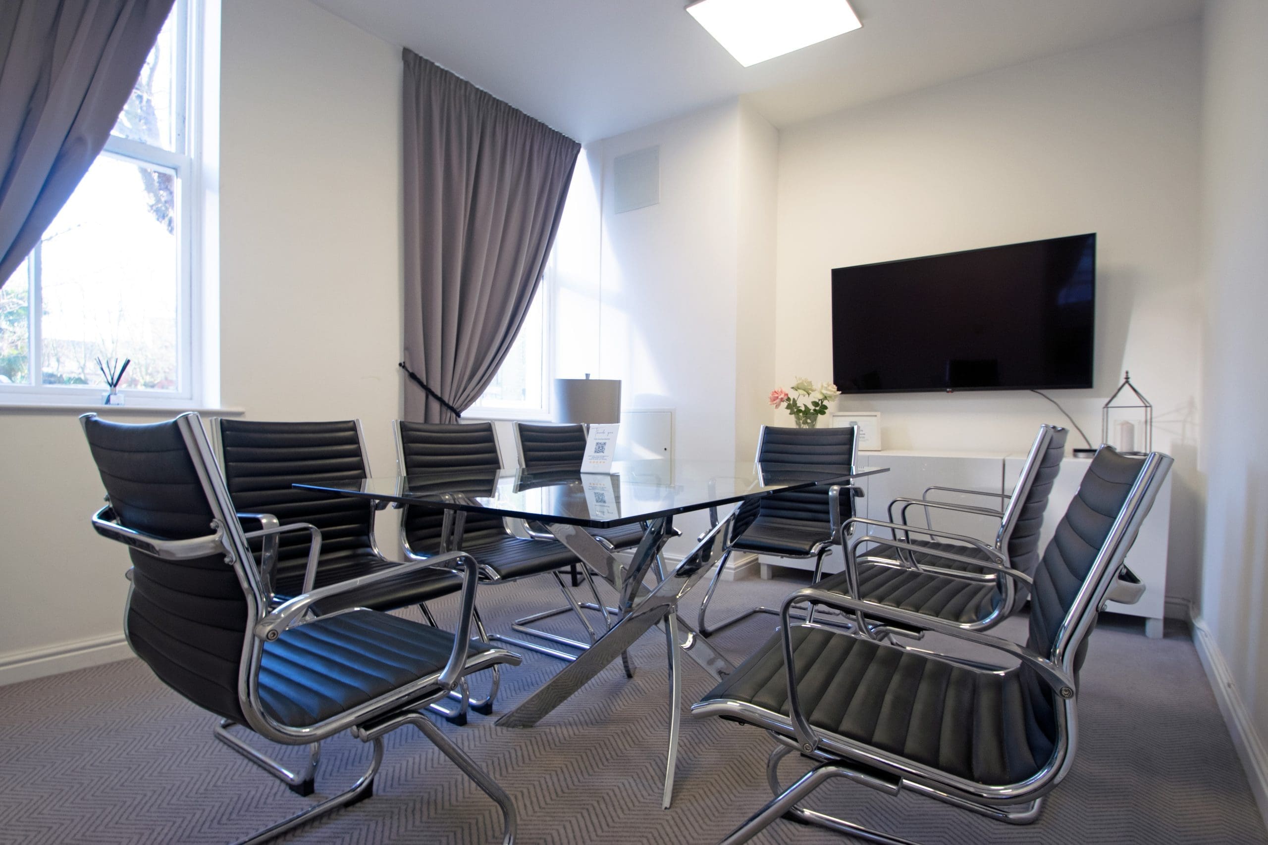 Modern meeting room at Grosvenor House with glass table, ideal for corporate events.