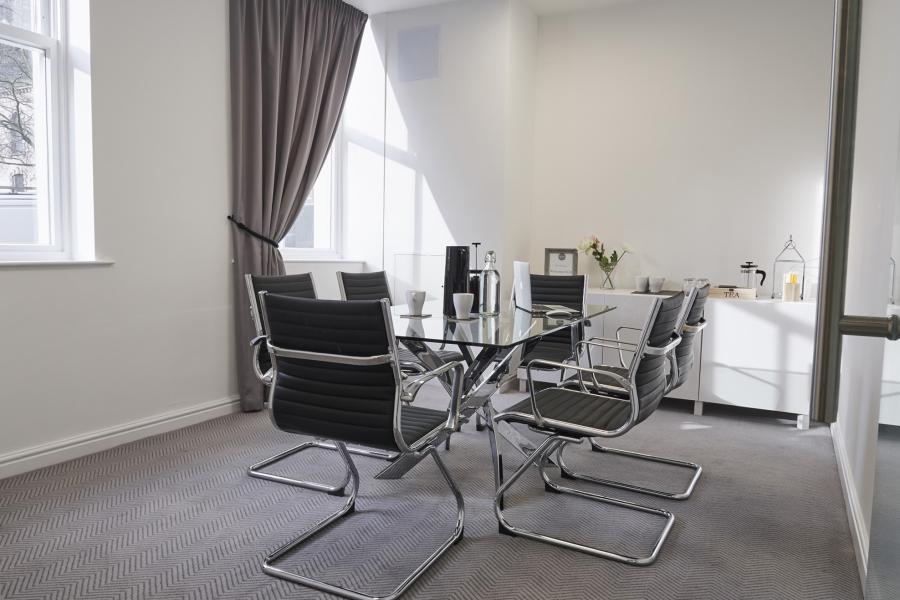 Modern meeting room at Grosvenor House with glass table, ideal for professional gatherings.