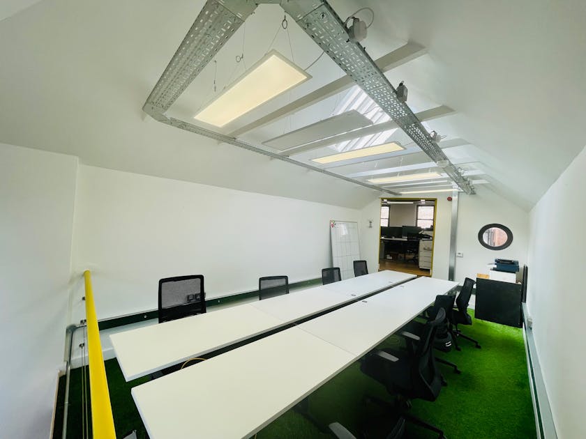 Modern coworking meeting room with white table, ideal for team brainstorming sessions.
