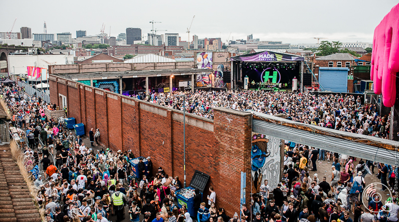 Vibrant outdoor festival at The Rainbow Venues with a large crowd and live entertainment.