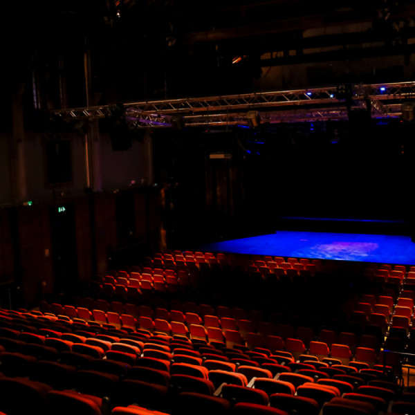 Live music venue in Harrow Arts Centre with blue-lit stage for events and performances.