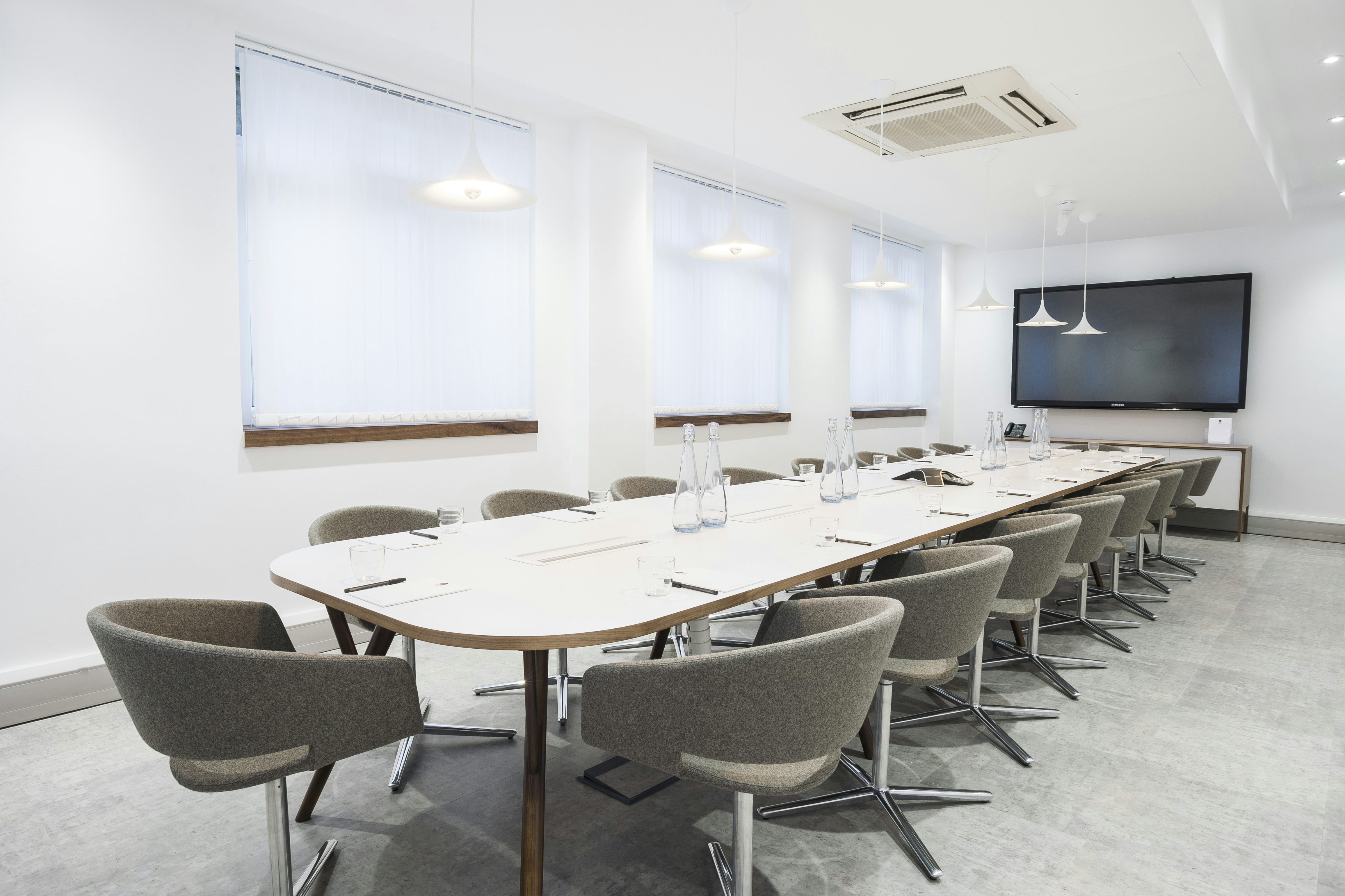 Modern meeting room with sleek table, ideal for corporate events and presentations.