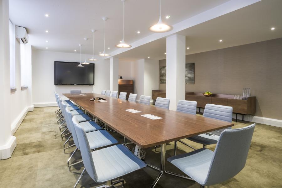 Modern conference room with wooden table, ideal for corporate meetings and events.