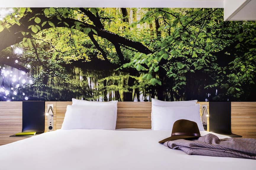 Serene hotel room with nature mural, ideal for retreats and wellness events.