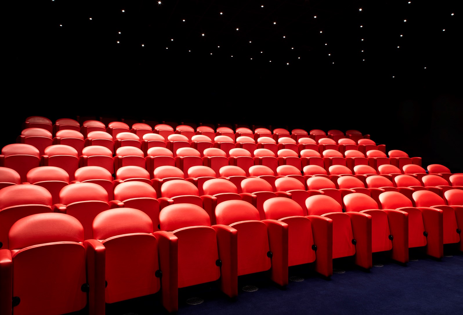 Soho Hotel screening room with vibrant red seating for presentations and events.