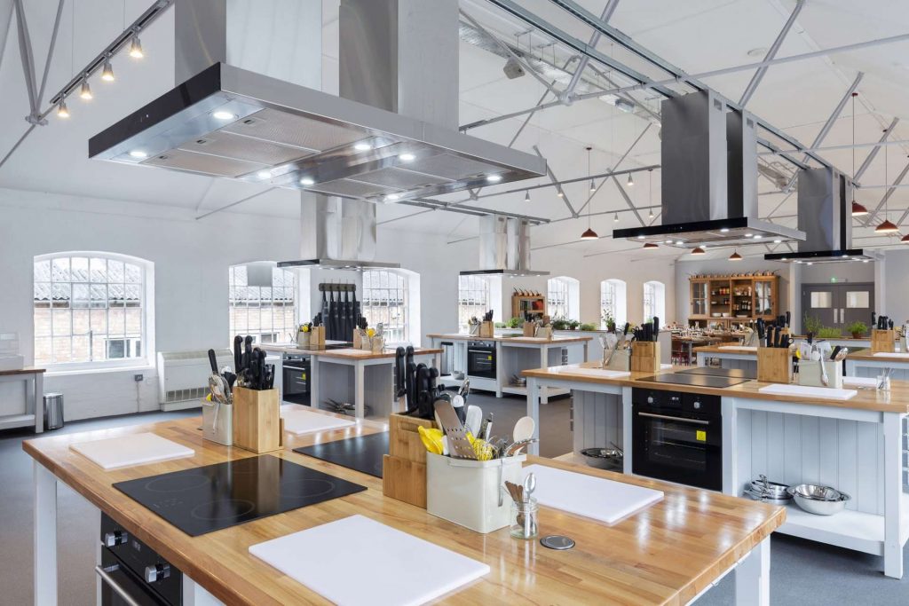 Modern kitchen venue for culinary events and workshops, ideal for team-building activities.