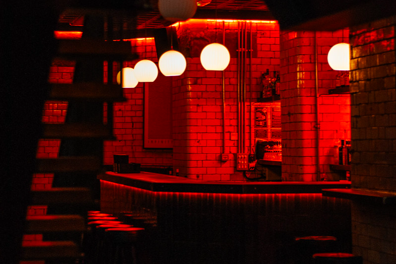Stylish bar with red ambiance, perfect for networking events and cocktail receptions.