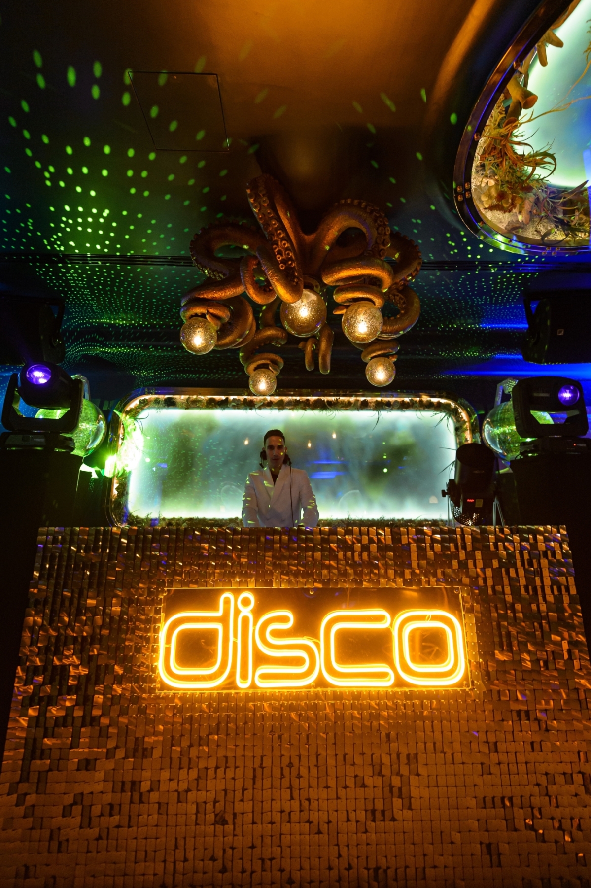 DJ booth with dynamic lighting at ALL IS JOY, perfect for nightlife events and parties.