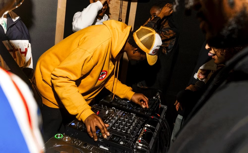 DJ booth at ALL IS JOY event, creating an energetic atmosphere with vibrant music.