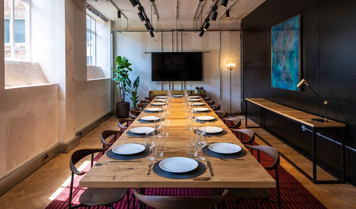 Modern meeting room with wooden table, ideal for corporate events and workshops.