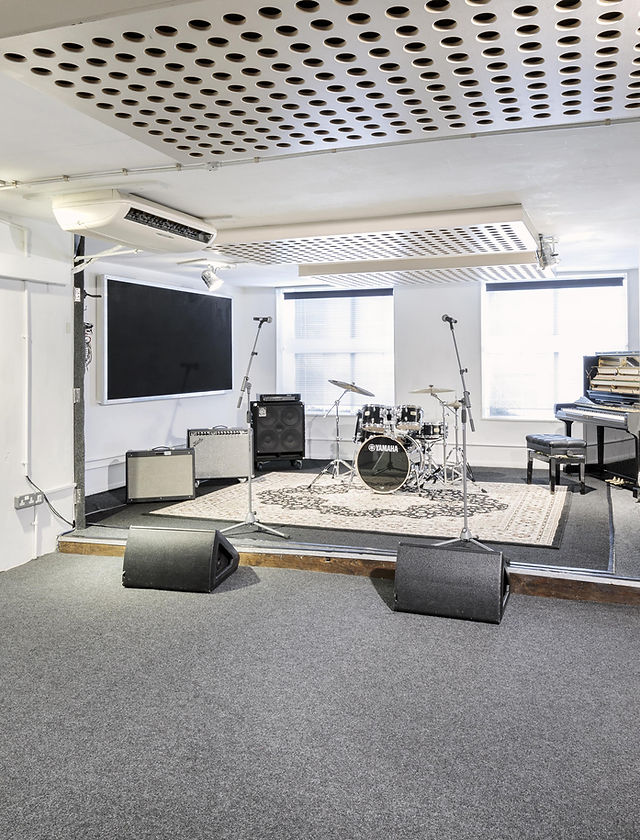Versatile event space with stage and sound equipment for live performances and presentations.