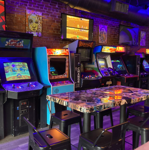 Vibrant arcade bar with classic machines, ideal for networking and team-building events.