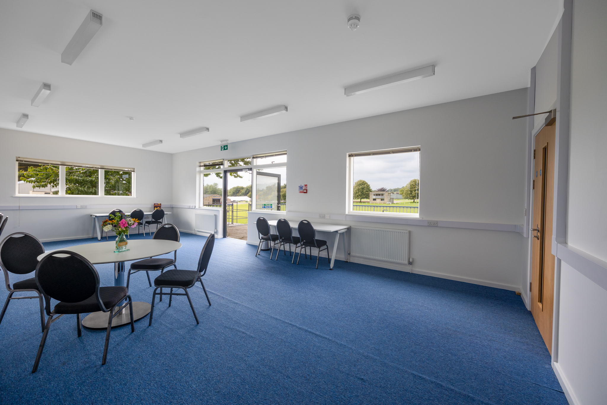 Bright Conference Suite with round tables, ideal for workshops and gatherings at Bath & West Showground.