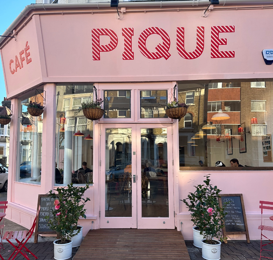 Charming pink café with outdoor seating, perfect for casual meetings and events.