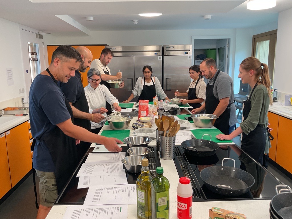 Team-building cooking class in modern ApplebyBlue Kitchen, fostering collaboration and creativity.