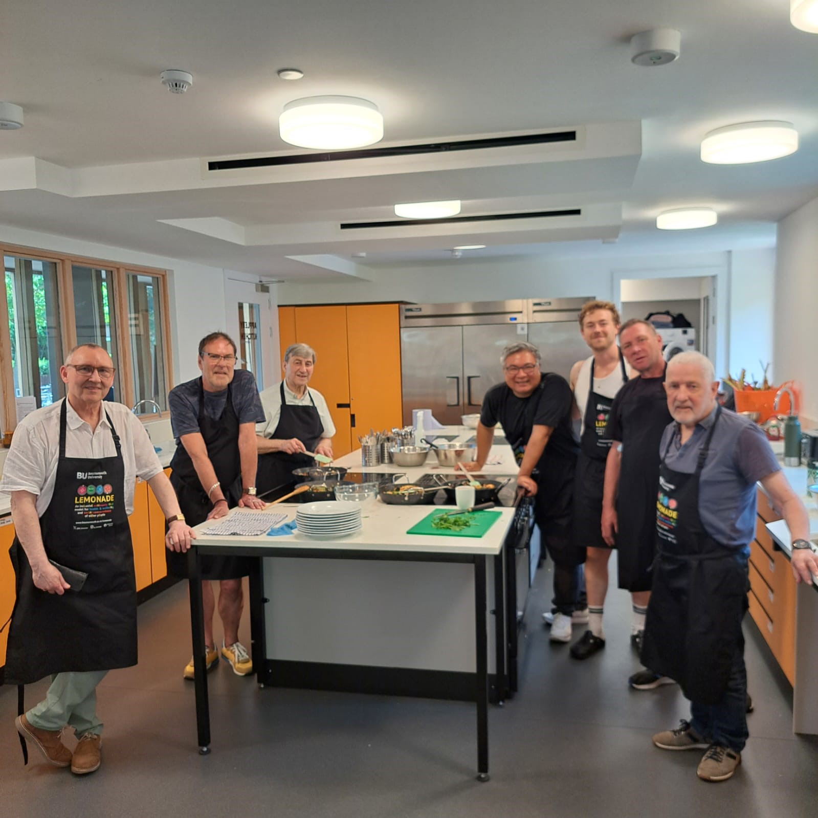 Group cooking activity in modern ApplebyBlue Kitchen, ideal for team-building events.