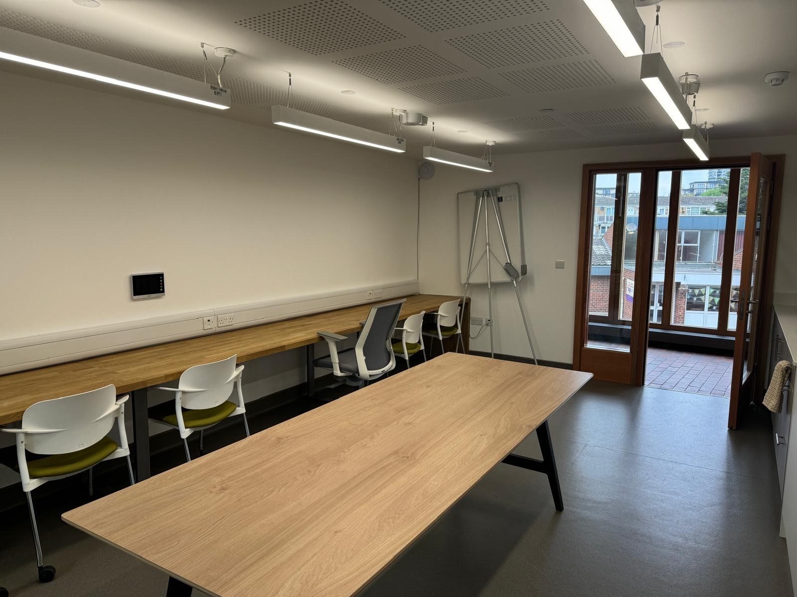 Modern meeting room with large wooden table in Appleby Blue Almshouse for collaboration.